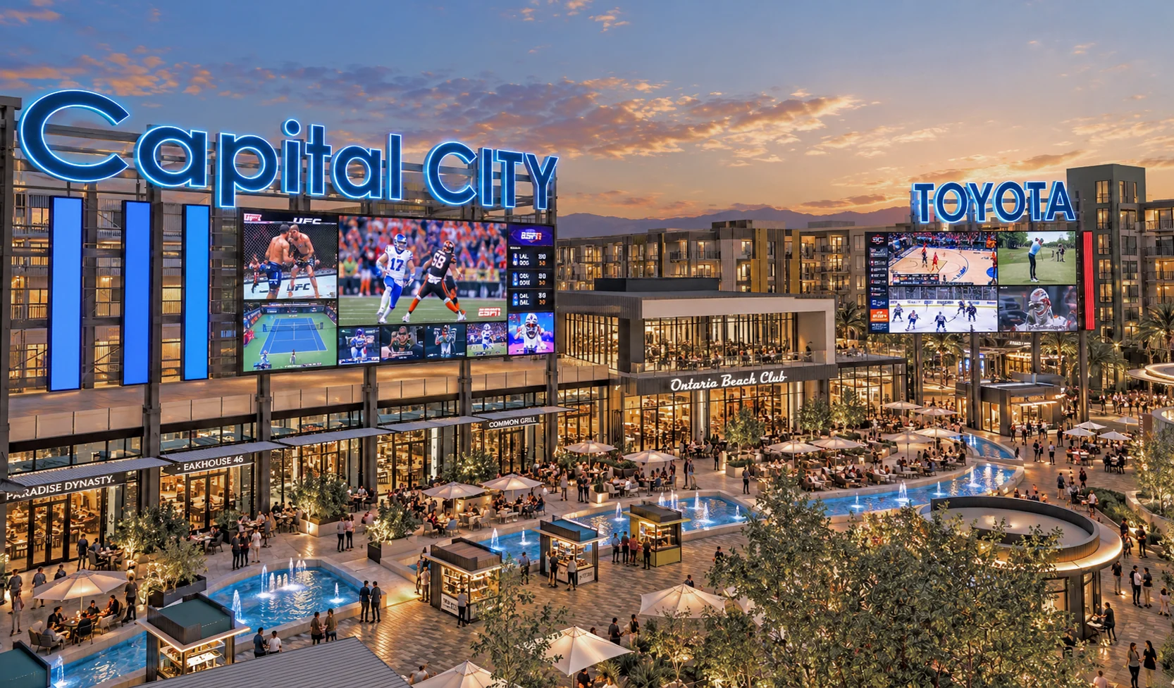 The Plaza at dusk: the Capital City sign and large screens lit above the patios and water features